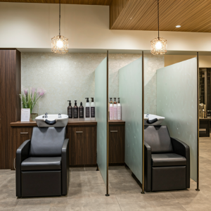 hair washing stations in a semi-private area with dividers for salon client comfort and privacy