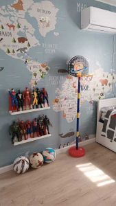 Kindergarten wallpaper mural world map decorated with various cartoon animals positioned in their approximate native regions such as a polar bear in Greenland and a Camel in the Middle East.